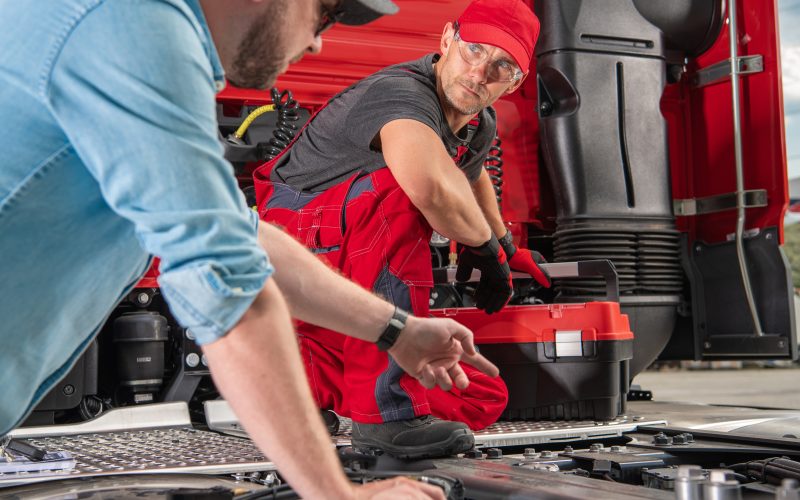 Truck Driver Pointing the Issue to His Mechanic